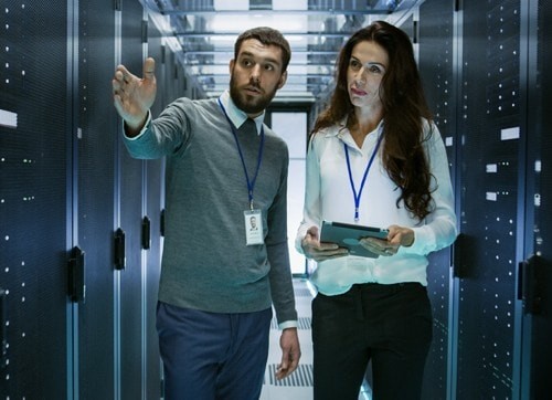 Man and woman walking through server room